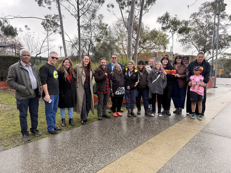 A large group of people standing together on a path outdoors.