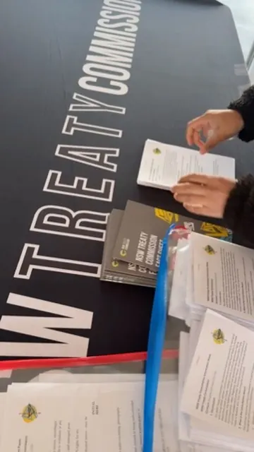 Printed campaign booklets and papers for the NSW Treaty Commission on a table.