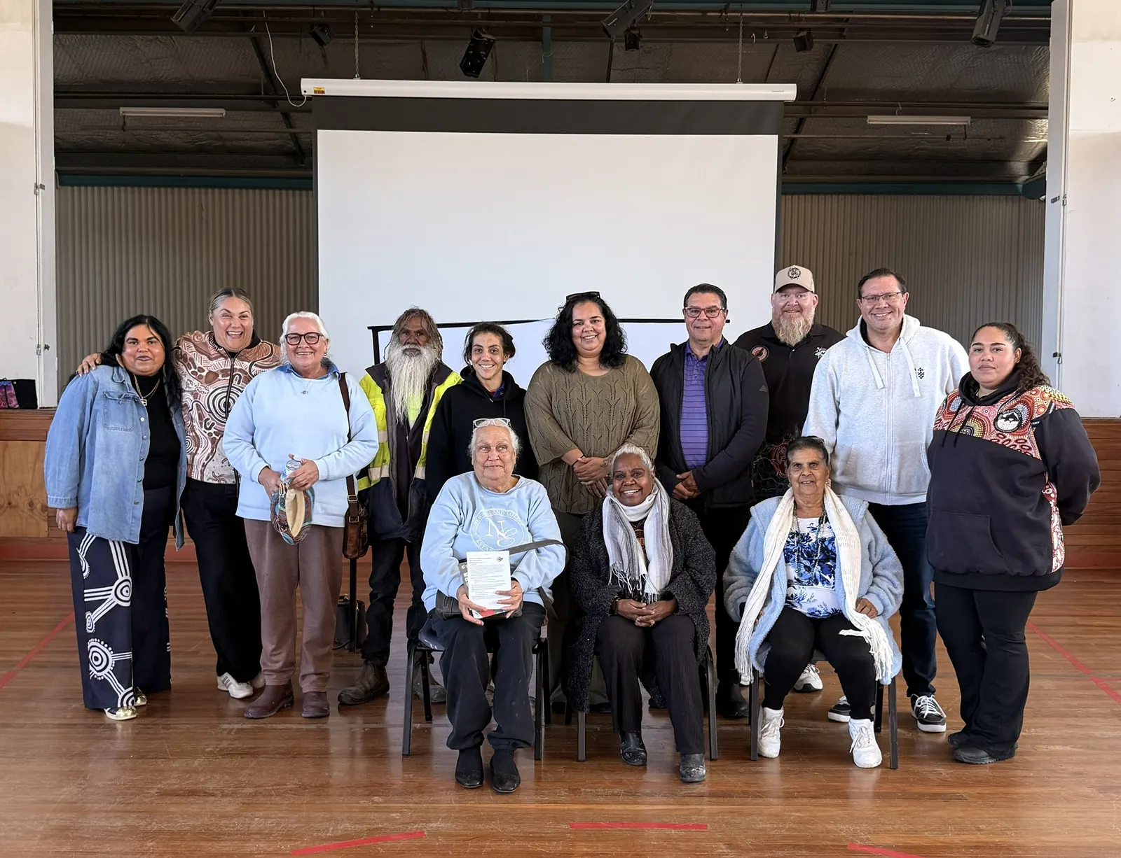 Community members and Elders gathered together in a hall.