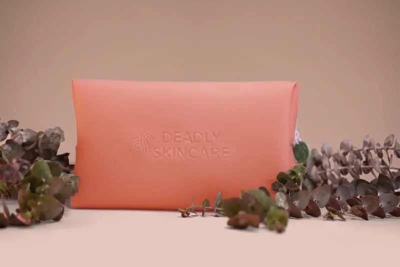 A pink Deadly Skincare pouch with dried native flowers.